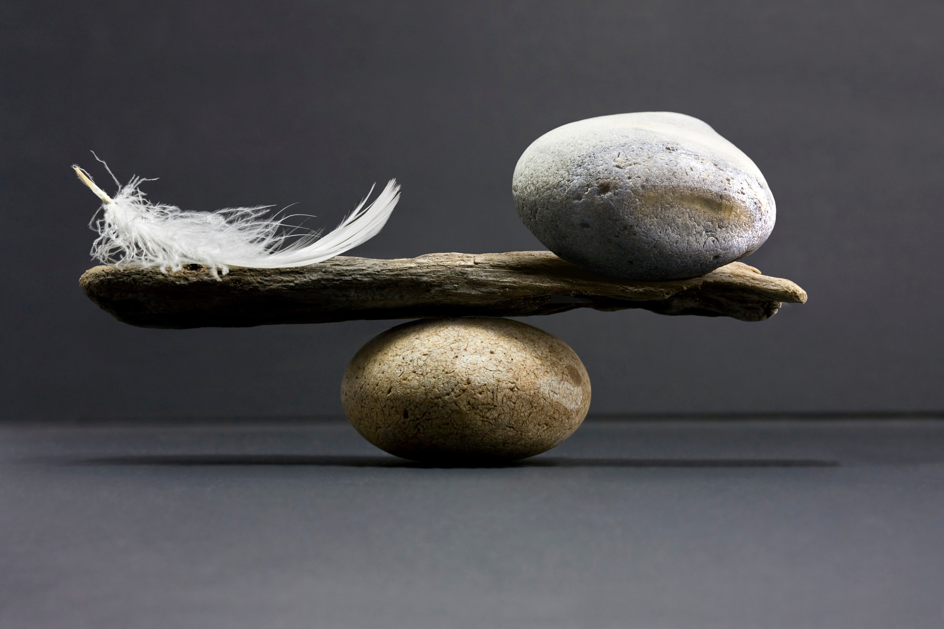 A feather and a stone equally balanced.