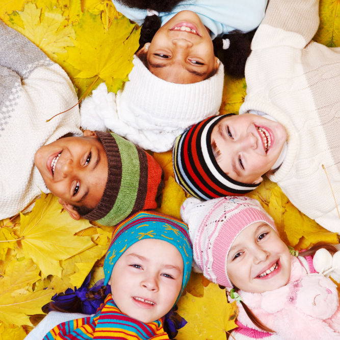 Group of smiling children on autumnal leaves